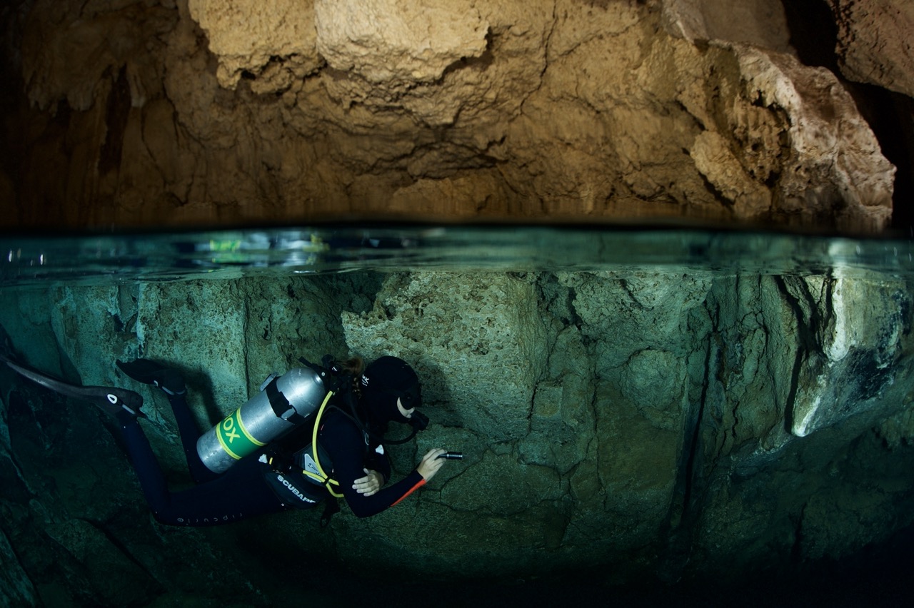 Underwater image capturing a diver exploring Chandelier Cave in a split shot.