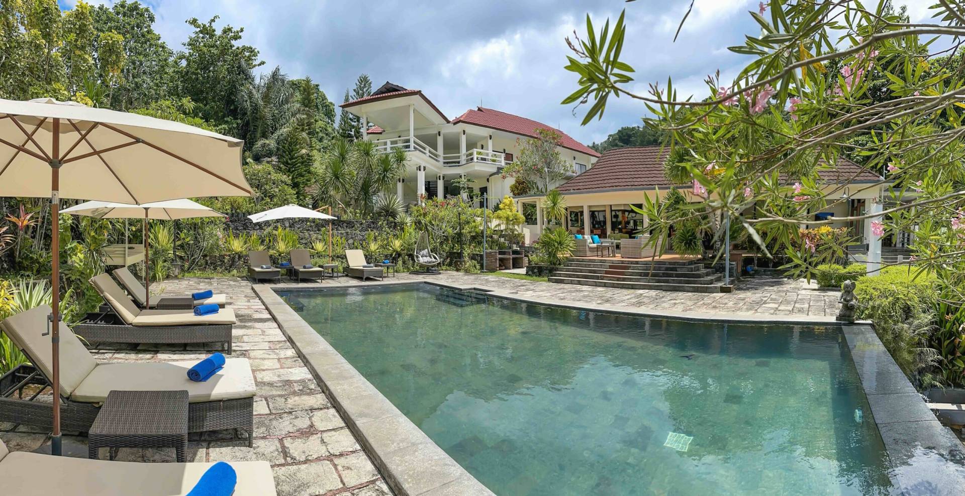 The view of gardens, Infinity pool, restaurant, and main building of Solitude Lembeh Resort after renovation